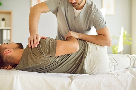 Chiropractor working on a patient laying on a treatment table